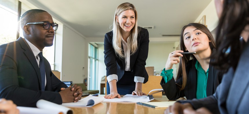 People hold meeting around table at a conference room.