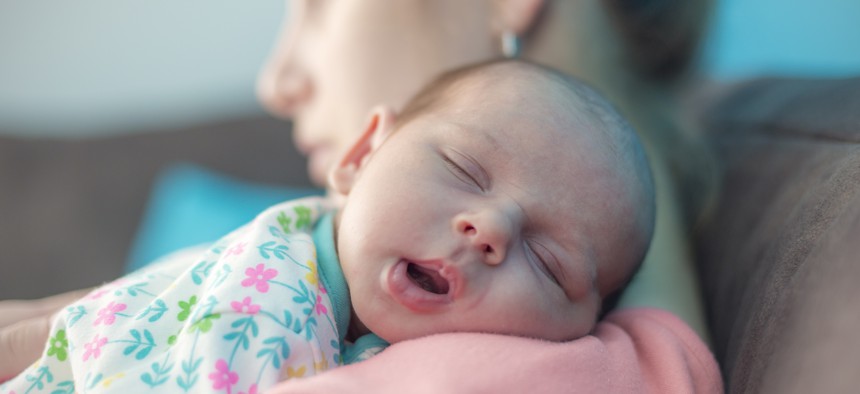 Baby rests on mother's shoulder.