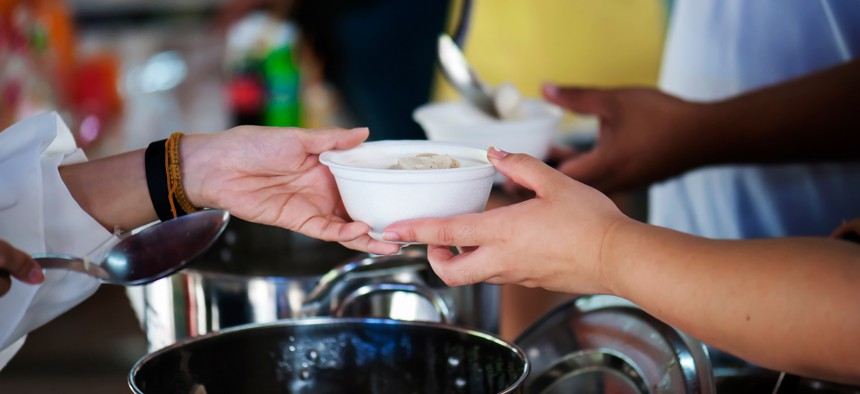 Person handing cup of food.