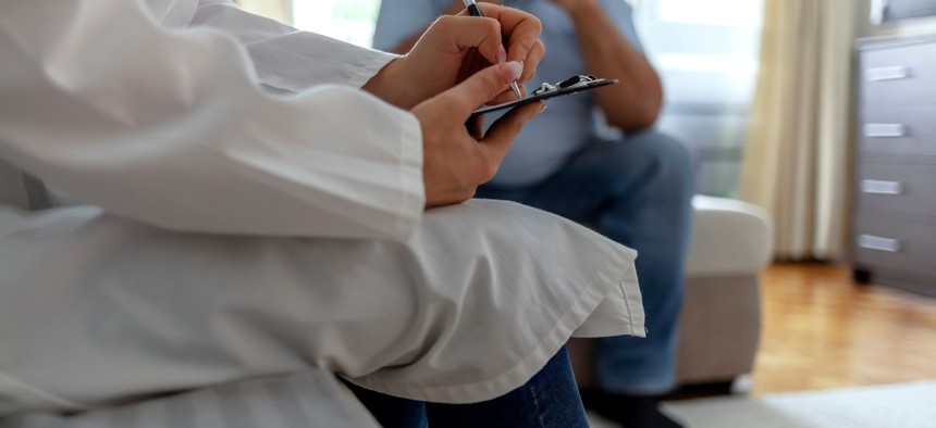 Mental health professional takes notes while listening to patient.