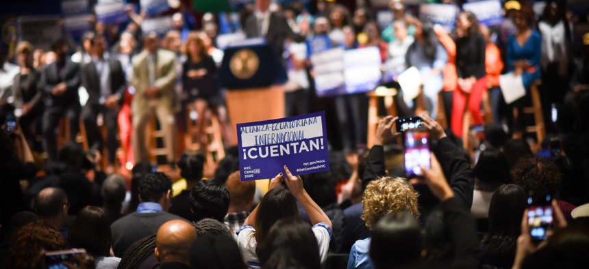 People raise signs calling to sign for the 2020 census.