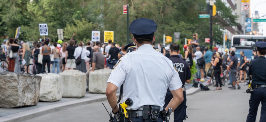Police officer in New York City standing in front of protests following police shooting Jacob Blake.