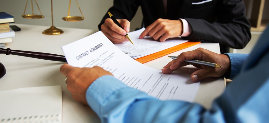 A lawyer looks over legal document for another person.  