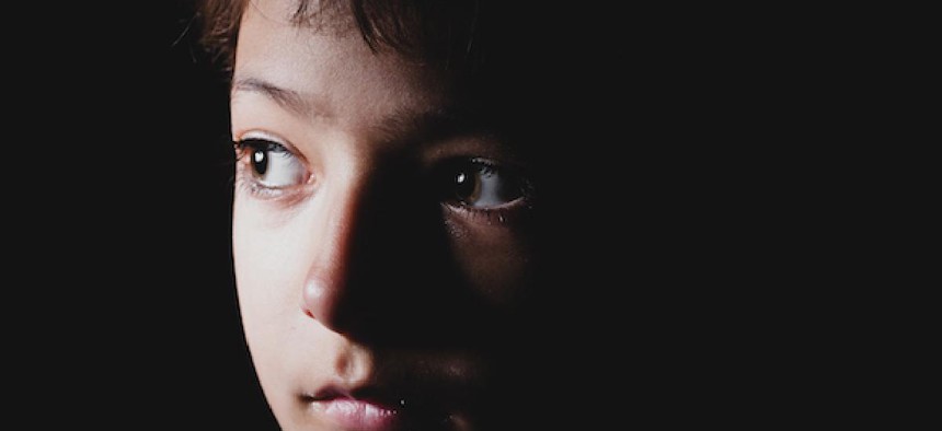 A young child looking at a window.