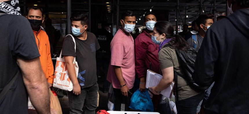 A group of migrants wait in line outside Port Authority Bus Terminal to receive humanitarian assistance on August 10, 2022 in New York. 