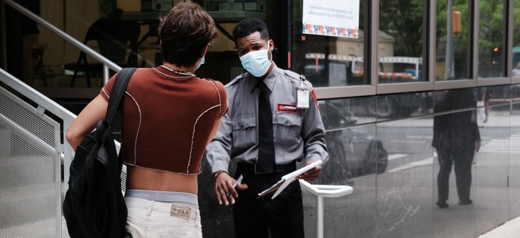 A security guard speaks to people at a health care facility that is administering the monkeypox vaccine by appointment earlier this month in New York City.