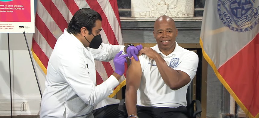 New York City Mayor Eric Adams receives a booster shot from Health Commissioner Ashwin Vasan.