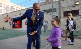 New York City School Chancellor David Banks welcomes a young student on the first day of school on Sept. 8, 2022. Banks on Thursday announced the city was replacing its controversial school admissions process.