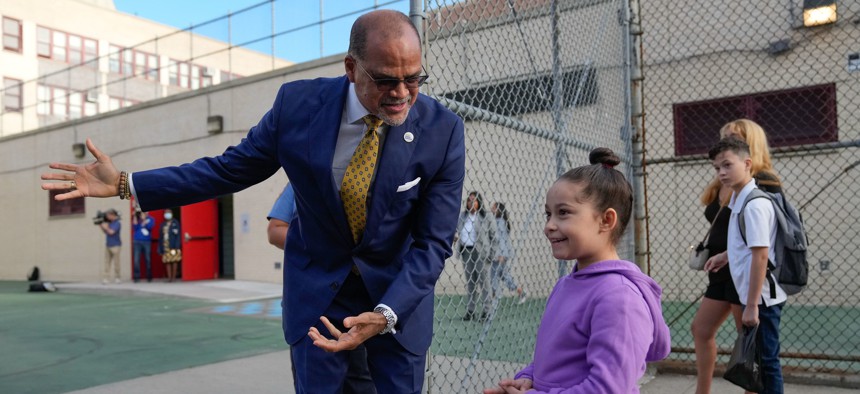 New York City School Chancellor David Banks welcomes a young student on the first day of school on Sept. 8, 2022. Banks on Thursday announced the city was replacing its controversial school admissions process.