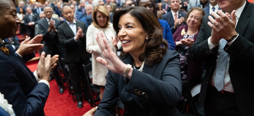 Gov. Kathy Hochul enters the Assembly Chamber for her State of the State address while state Senators from New York City look on.
