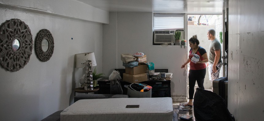 Two residents of a basement apartment in Queens attempt to clean up after flooding from remnants of Hurricane Ida in 2021.