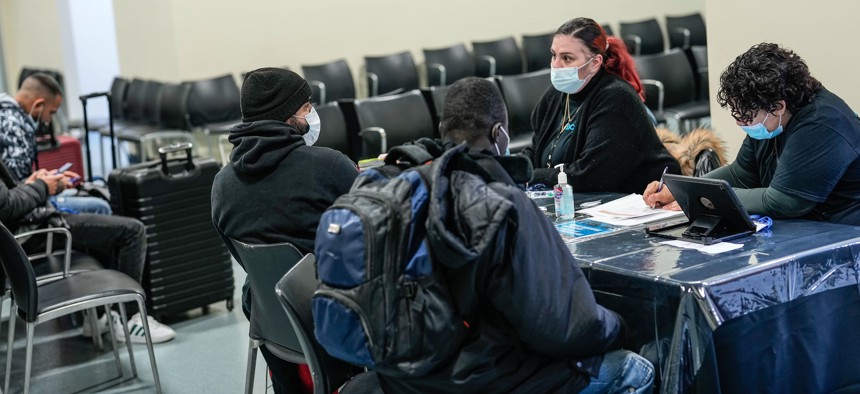 Asylum-seekers speak with support services workers at the Brooklyn Cruise Terminal in Red Hook last month.