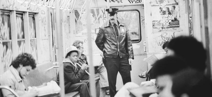 A policeman on duty on a New York City subway train in the 1970s