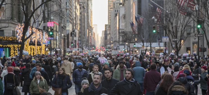 People walk along Fifth Avenue during the Open Streets program on December 18, 2022 in New York City. 
