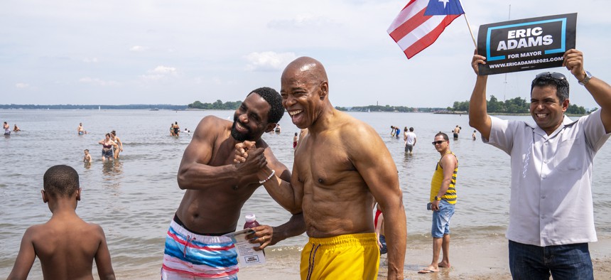 Eric Adams poses for a photo with beachgoers at Orchard Beach in the Bronx, while campaigning for mayor on June 19, 2021.