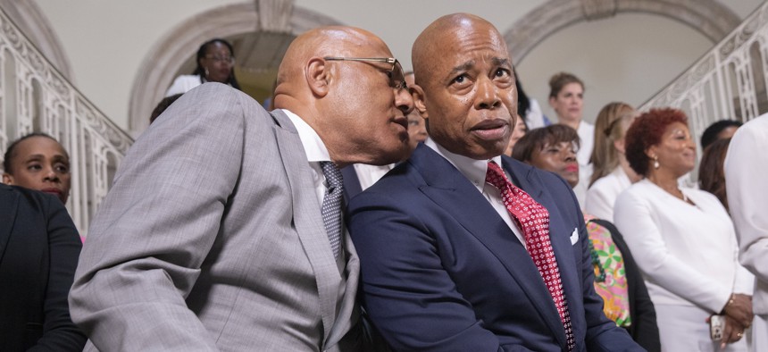 Budget Director Jacques Jiha whispers to Mayor Eric Adams at the fiscal year 2024 budget handshake press conference. 