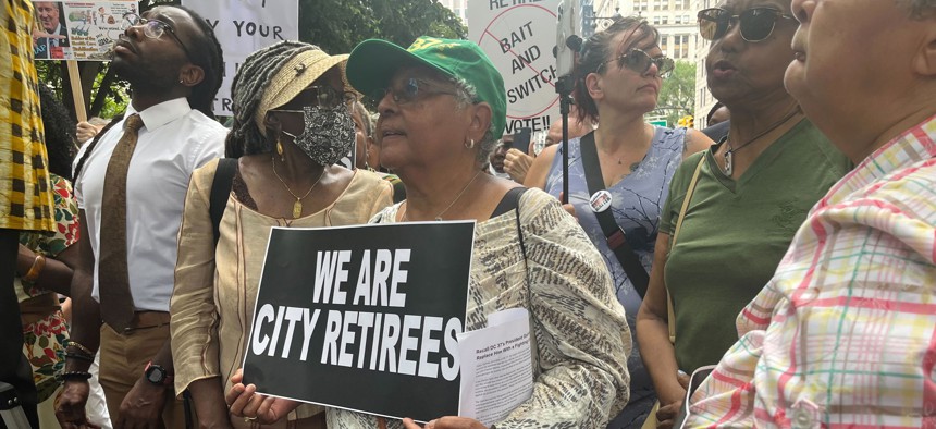 A retiree attends a rally at City Hall on July 13.