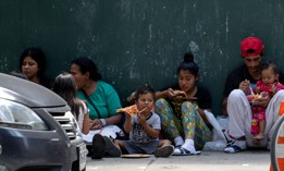 A migrant family waits outside the Roosevelt Hotel in Manhattan in August. 