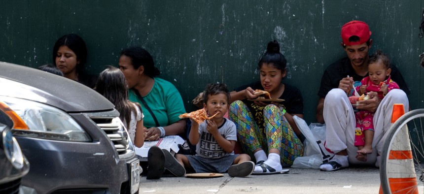 A migrant family waits outside the Roosevelt Hotel in Manhattan in August. 