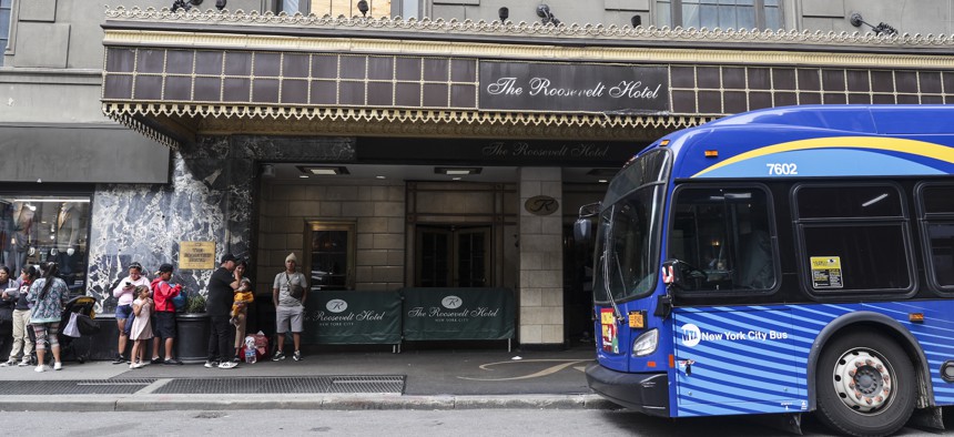 Asylum-seekers line up outside the Roosevelt Hotel, which has become a base for shelter assignments and migrant casework.