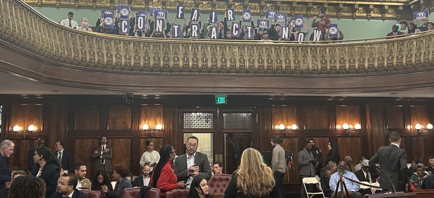Members of the Association of Legislative Employees hold up signs reading “Fair Contract Now” during a stated meeting of the City Council on Dec. 6, 2023.