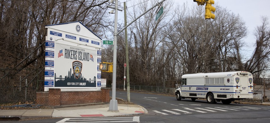 A Department of Corrections bus drives up to the entrance of the bridge that connects to Rikers Island.