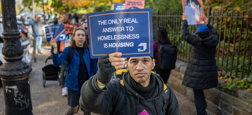 A protester holds up a sign during a rally and “sleep in” outside Gracie Mansion on November 16, 2023.