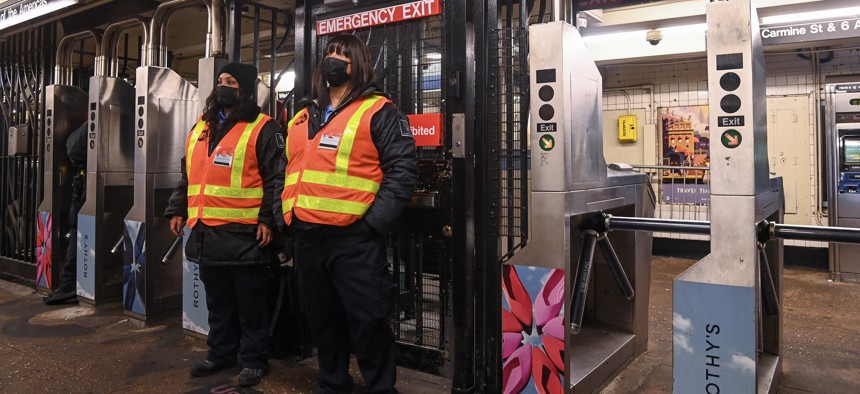 Unarmed security guard contractors block an emergency exit to deter fare evasion at the West 4th Street station in Manhattan.