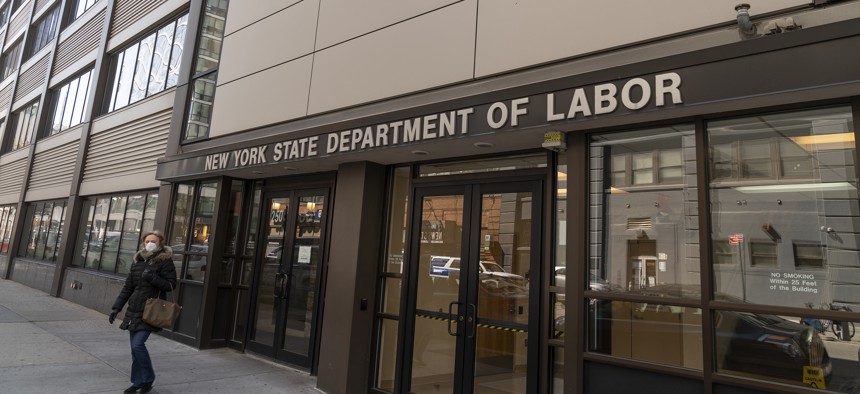 A woman walks past the New York State Department of Labor's office in Brooklyn on March 21, 2020.