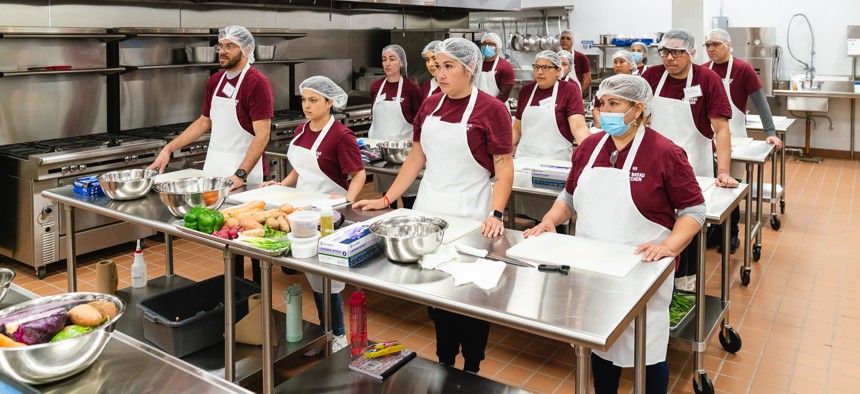 Newly arrived migrants receive their cooking instructions in Hot Bread Kitchen’s class.