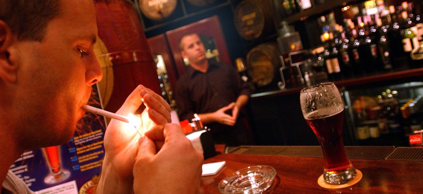 A smoker lights up a cigarette at a Times Square bar in 2002 before New York City banned smoking at bars and restaurants.