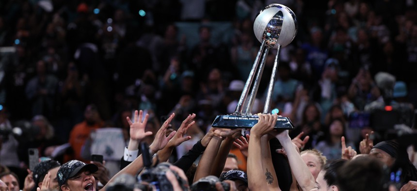 New York Liberty players hoist the WNBA championship trophy after winning Game Five of the WNBA Finals on Oct. 20, 2024.