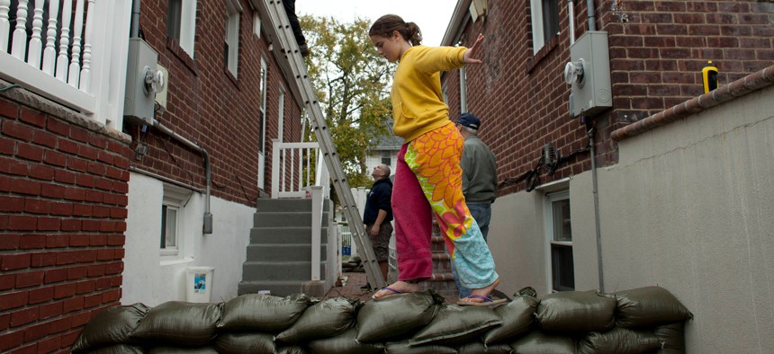 Bridget Donnelly walks on a sandbag wall outside her home in the Rockaways out in Queens as Hurricane Sandy approached on October 28, 2012.