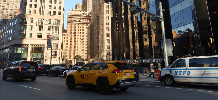 A taxi passes under a congestion pricing toll reader above Columbus Circle on Dec. 23, 2023.