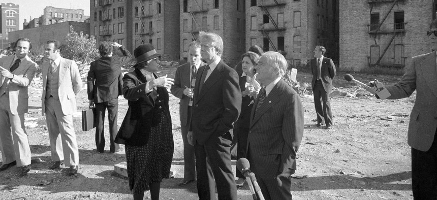 President Jimmy Carter stands in front of burned buildings in the South Bronx in 1977.