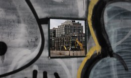 A new building going up in Gowanus is visible through a temporary construction wall.