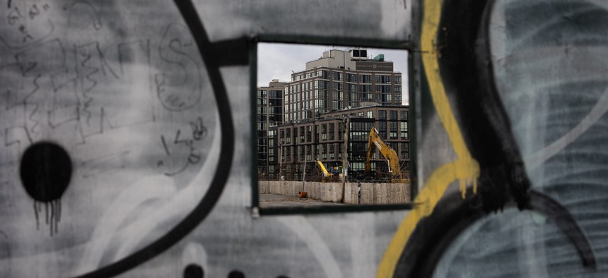 A new building going up in Gowanus is visible through a temporary construction wall.