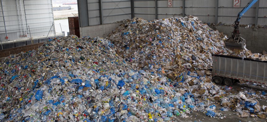 Workers collect the day’s recycled trash at a city recycling center processing plant in Brooklyn on April 11, 2019.