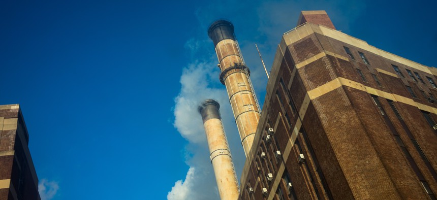 Smoke and condensation flow out of smokestacks at a power plant in Manhattan.