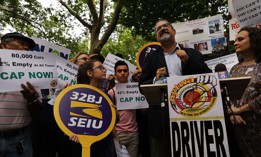 32BJ SEIU President Hector Figueroa speaks at a rally in front of City Hall in support of a cap on the number of for-hire vehicles, on July 31, 2018.