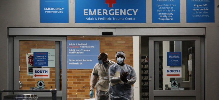 Medical workers walk outside a special coronavirus area at Maimonides Medical Center on May 26, 2020.