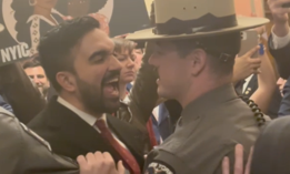 Assembly Member Zohran Mamdani, left, shouts questions at President Donald Trump’s border czar Tom Homan as state troopers hold him back, inside the state Capitol on March 12, 2025.