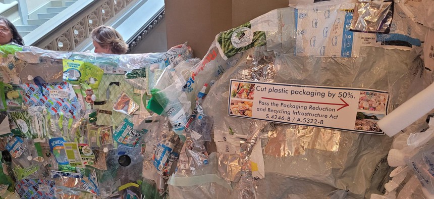 Environmental advocates display discarded plastic packaging outside the Assembly chamber on June 3, 2024.