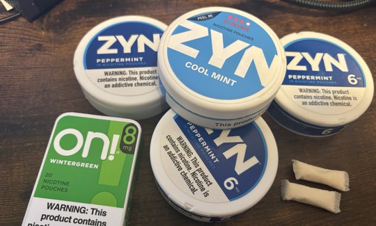 A collection of tins containing nicotine pouches.