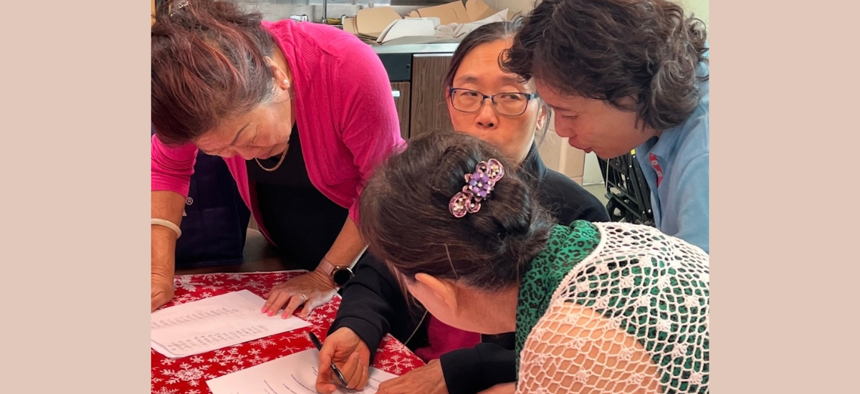 Individuals of Chinese descent at an Asian senior center completing surveys on language access in the Asian American community.