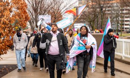 Brittan Hardgers, holding the blue megaphone, leading a group in the Rochester 2025 Trans Visibility March.