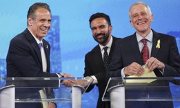 Former Gov. Andrew Cuomo, left, shakes hands with Assembly Member Zohran Mamdani, center, on the debate stage with fellow candidate Whitney Tilson.