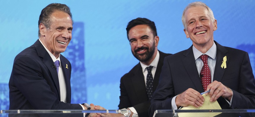 Former Gov. Andrew Cuomo, left, shakes hands with Assembly Member Zohran Mamdani, center, on the debate stage with fellow candidate Whitney Tilson.