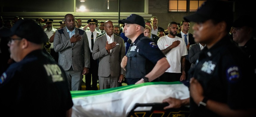 New York City Mayor Eric Adams watches as the body of the NYPD officer fatally shot by a gunman is transferred at New York Presbyterian.