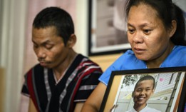 Chee War, mother of the late Nyah Mway, is overcome by emotion as she embraces his photo, with his father Ka Lee Wan on the left.